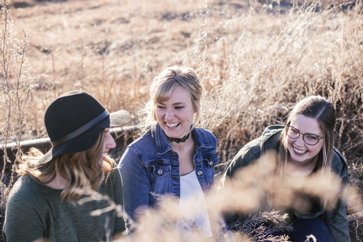 Photograph of three women laughing together.