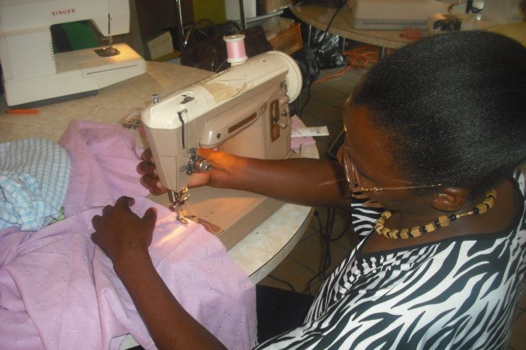 Photograph of a woman at a sewing machine.