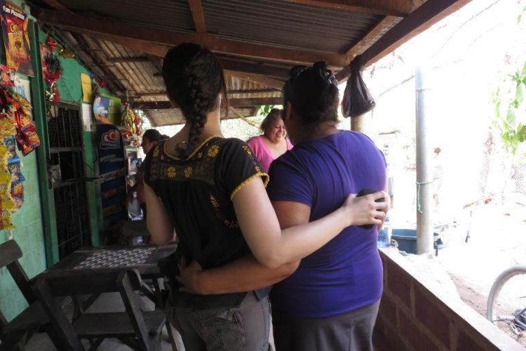 Photograph of two women with their arms around each other.