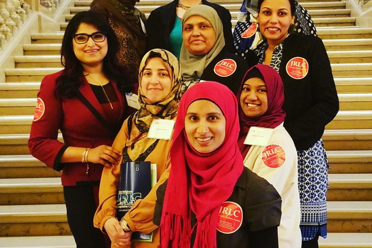 Photograph of nine young muslim women leaders from RISE, standing on steps.