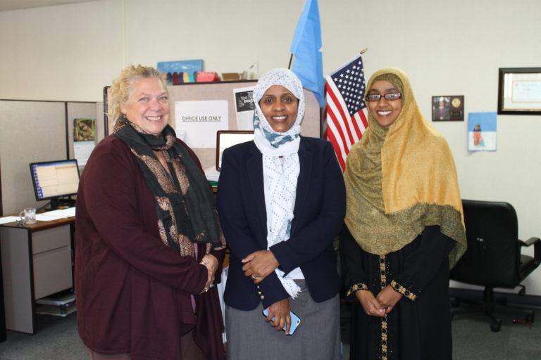 A white woman and two Somali women at the Isuroon office.