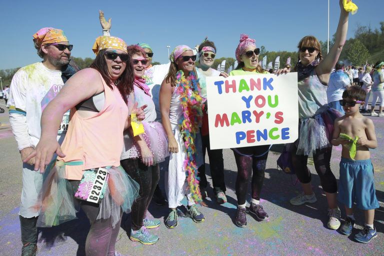 Photograph of MAYA organization participants holding a sign that says Thank You Mary's Pence.