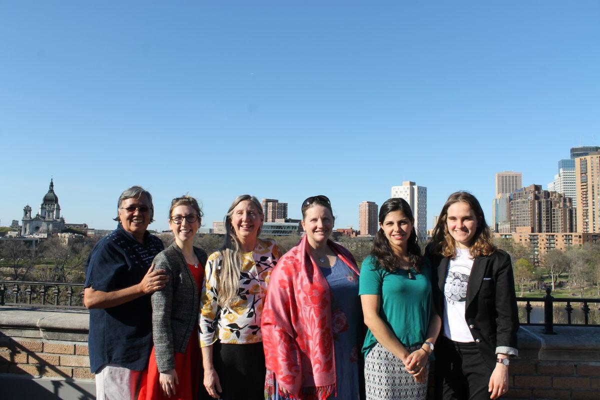 Photograph of Mary's Pence staff with the Minneapolis skyline in the background.