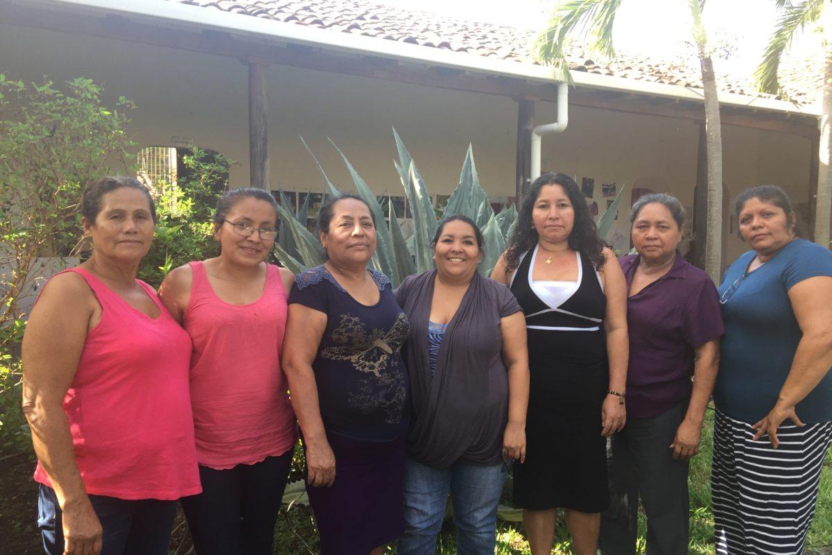 Photograph of the seven women leaders of Concera standing outside their building.