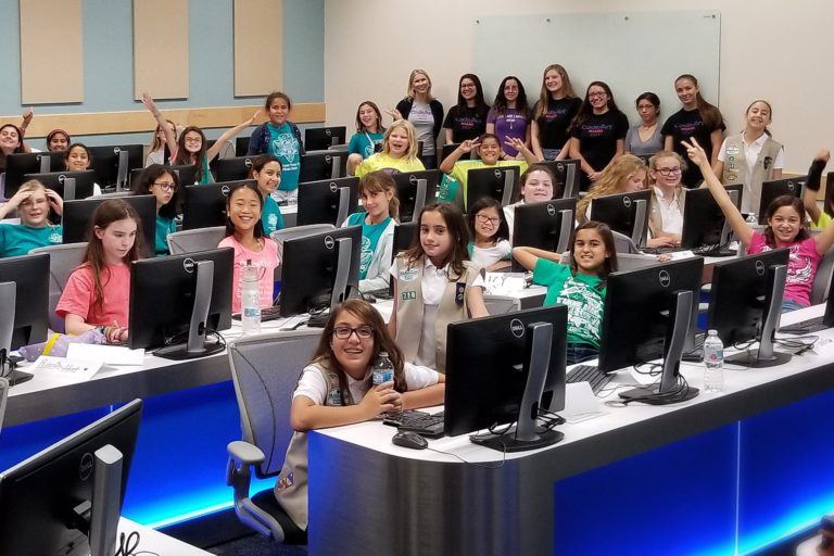 Photo of about 30 middle-school aged girls in a computer lab.