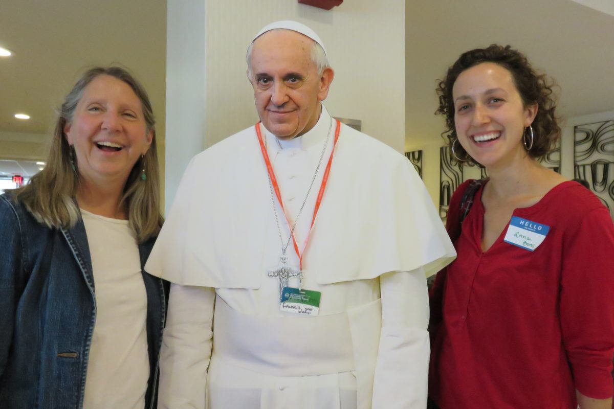 Photograph of Mary's Pence executive director Katherine Wojtan and another staff member laughing as they pose with a life-size cut out of Pope Francis.