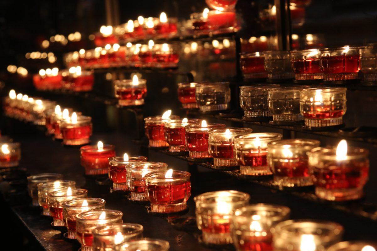 red tealights in glass votive holders set on racks.