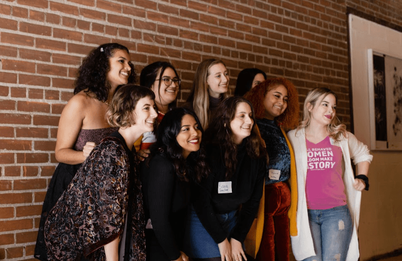 Members of Women for Political Change pose for a photo with brick background