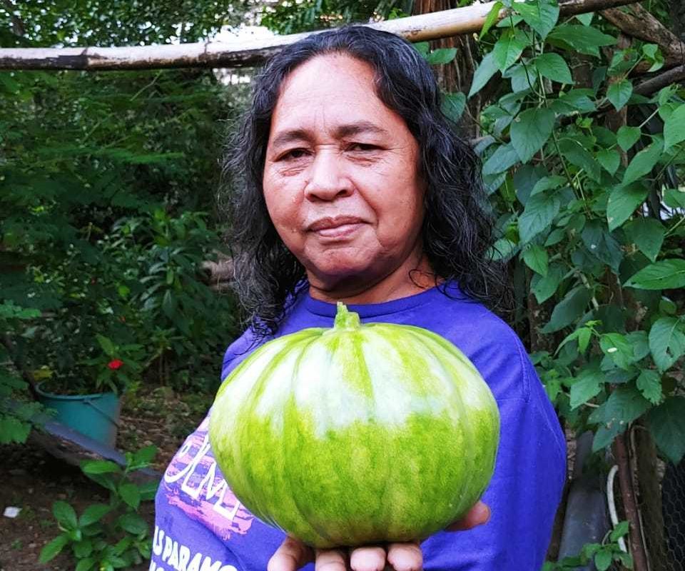 Ana María holding produce from the La Concerta farm